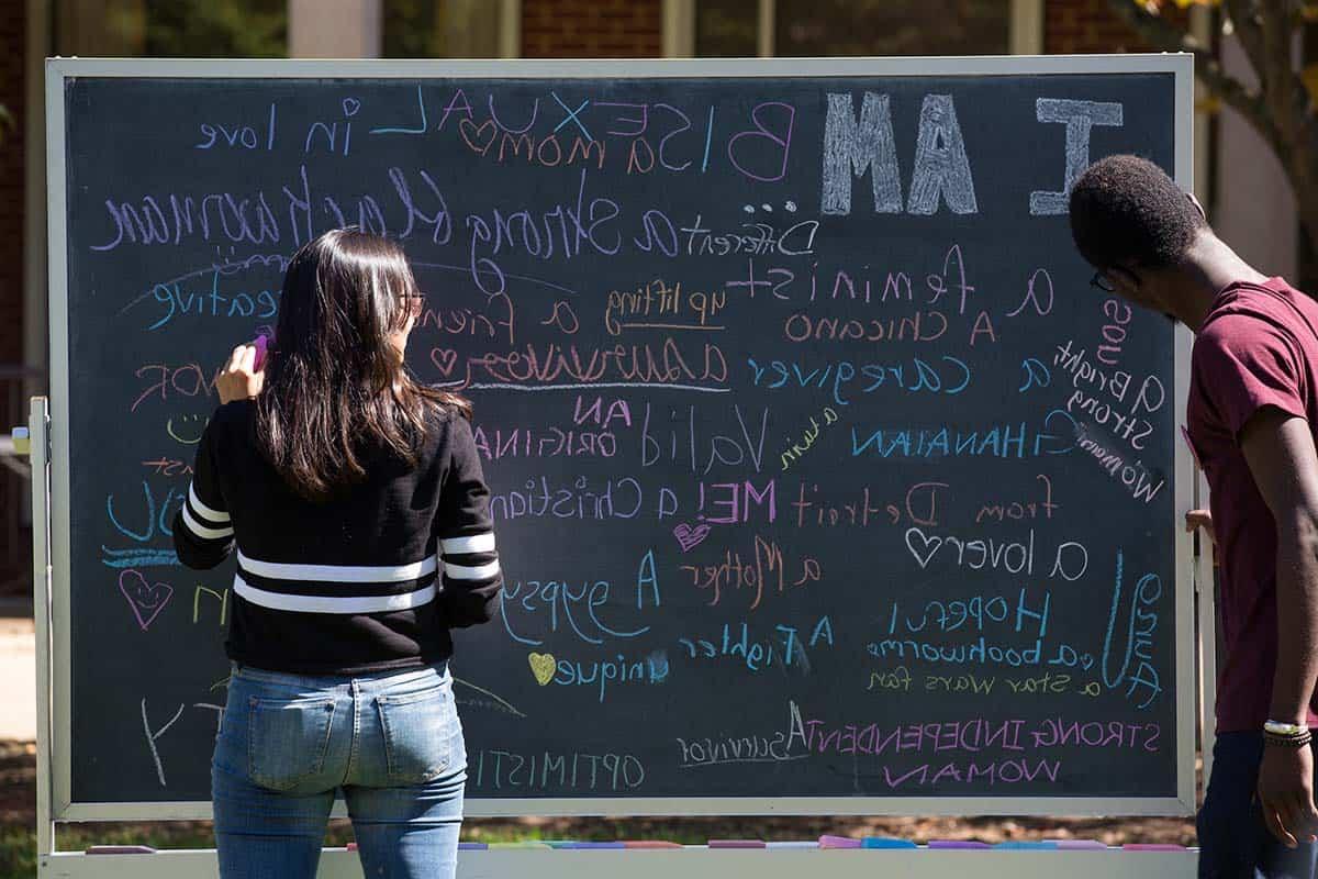 Students share their identities on a diversity chalkboard.